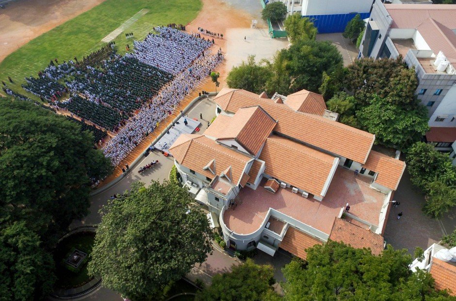 Aerial view of the school campus, building and morning assembly on the grounds